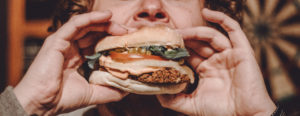 person biting into a burger